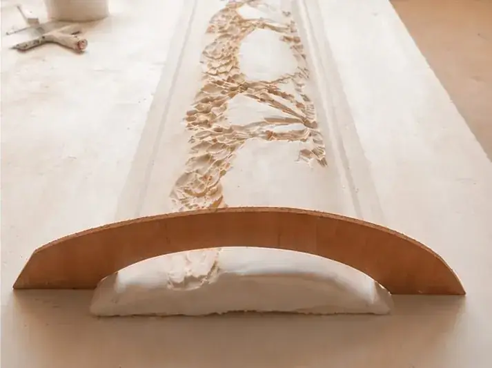 Panel curvo con relieve vegetal apoyado en una estructura