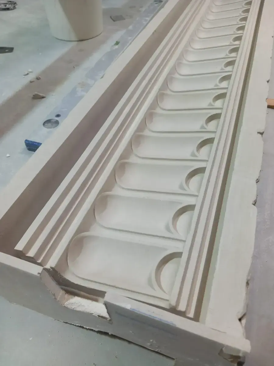 Panel alargado con molduras y relieves sobre la mesa